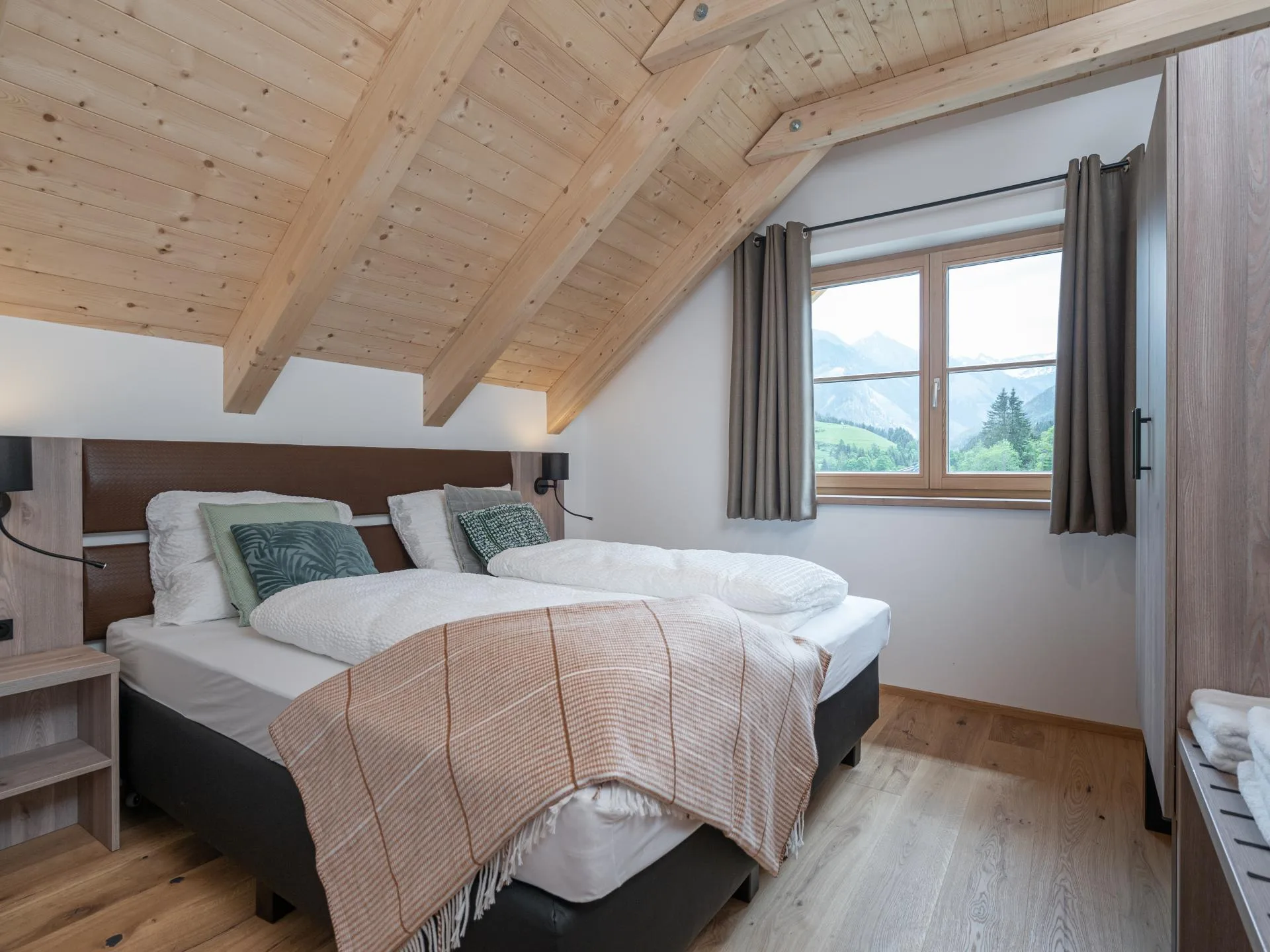 Haus Liene - Bright and airy bedroom with large windows, natural light and comfortable bedding for a restful mountain vacation